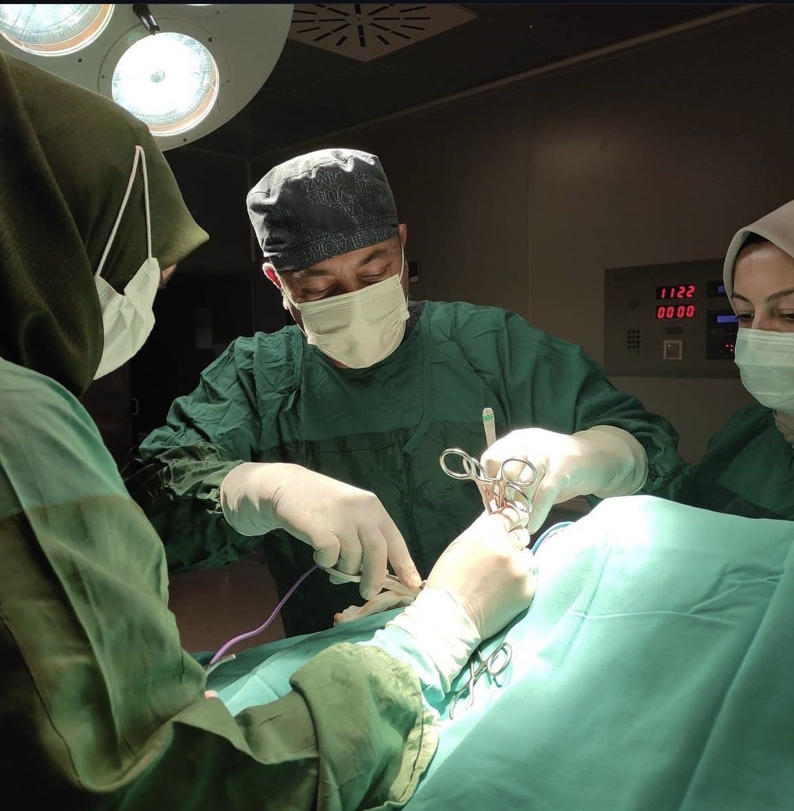 Op. Dr. Bülent Uysal ameliyat sırasında, ameliyat lambası altında ekibiyle birlikte